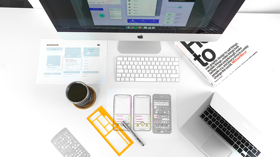 Wireframes and devices on a designer's desk