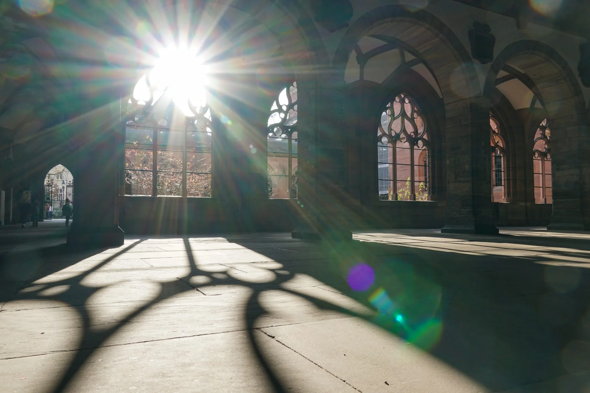 Sunlight streaming through a row of Gothic arches